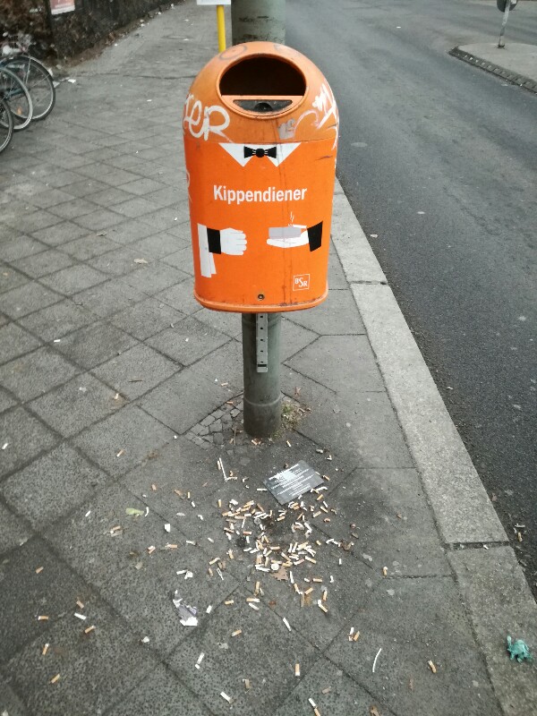 Streetphoto of a bin with loads of cigarettes on the floor near Sonnenallee Berlin by Stefan Klenke